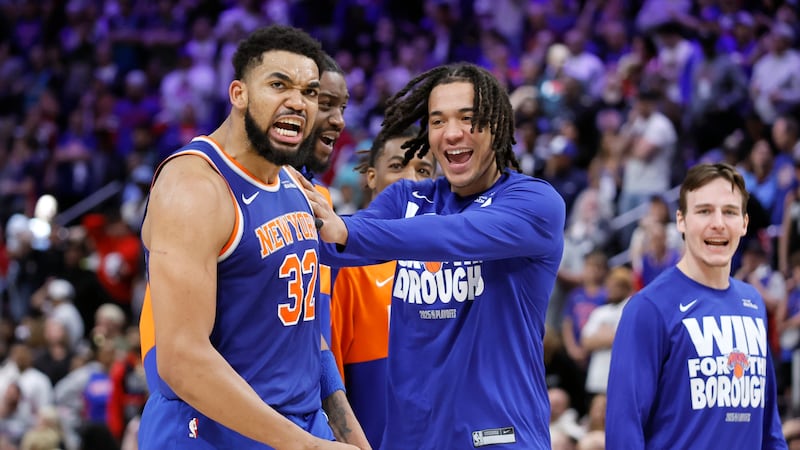 New York Knicks guard Pacome Dadiet, center, celebrates with center Karl-Anthony Towns (32)...