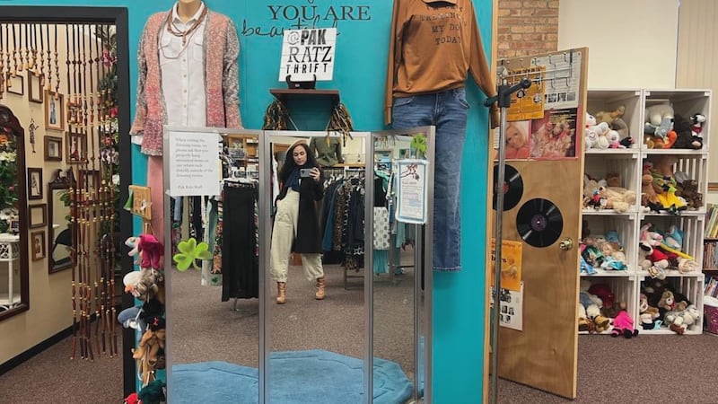 Tia Trudgeon poses in the mirror with new items from Pak Ratz Thrift Store.