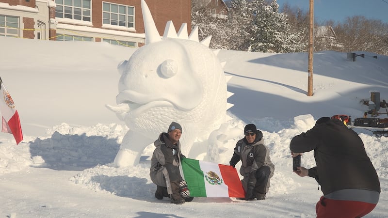 Members of Team Mexico pose next to their snow sculpture on Sunday.